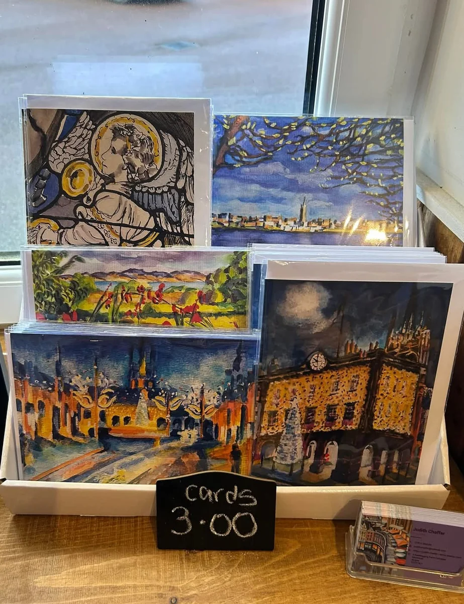 Colourful art cards displayed in a wooden rack
