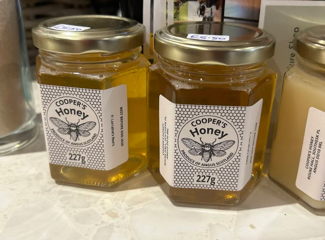 Jars of Cooper's local honey on a wooden shelf